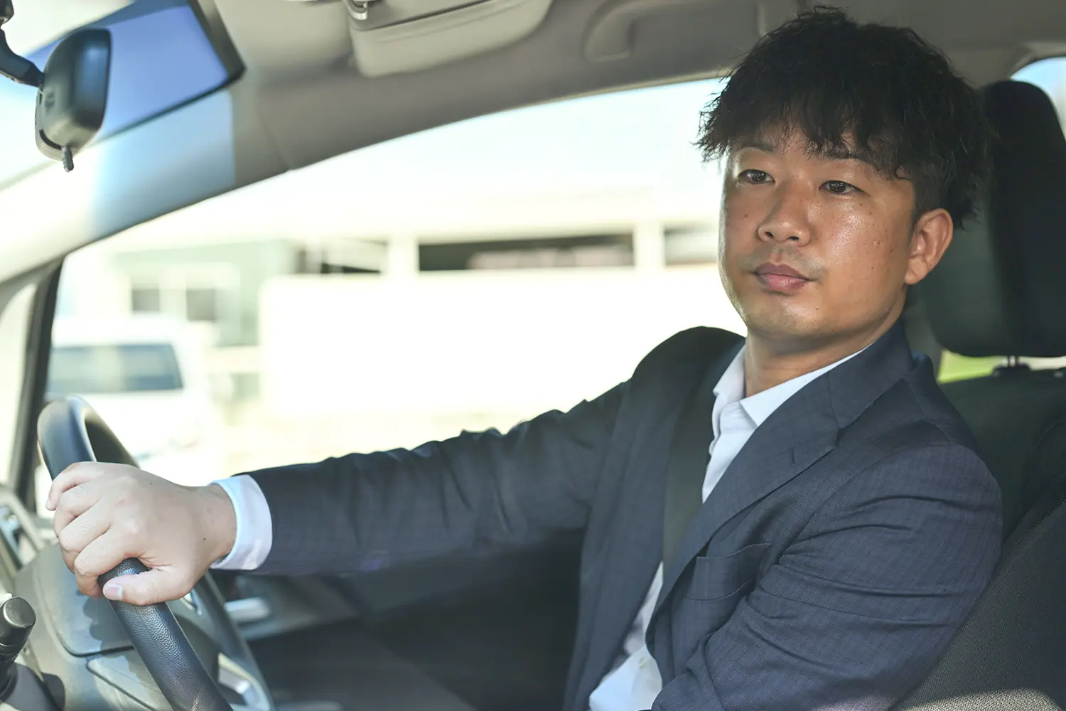 運転するスーツの男性