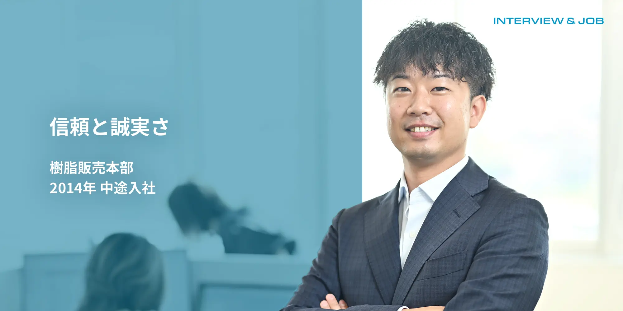 腕を前に組んだスーツの男性